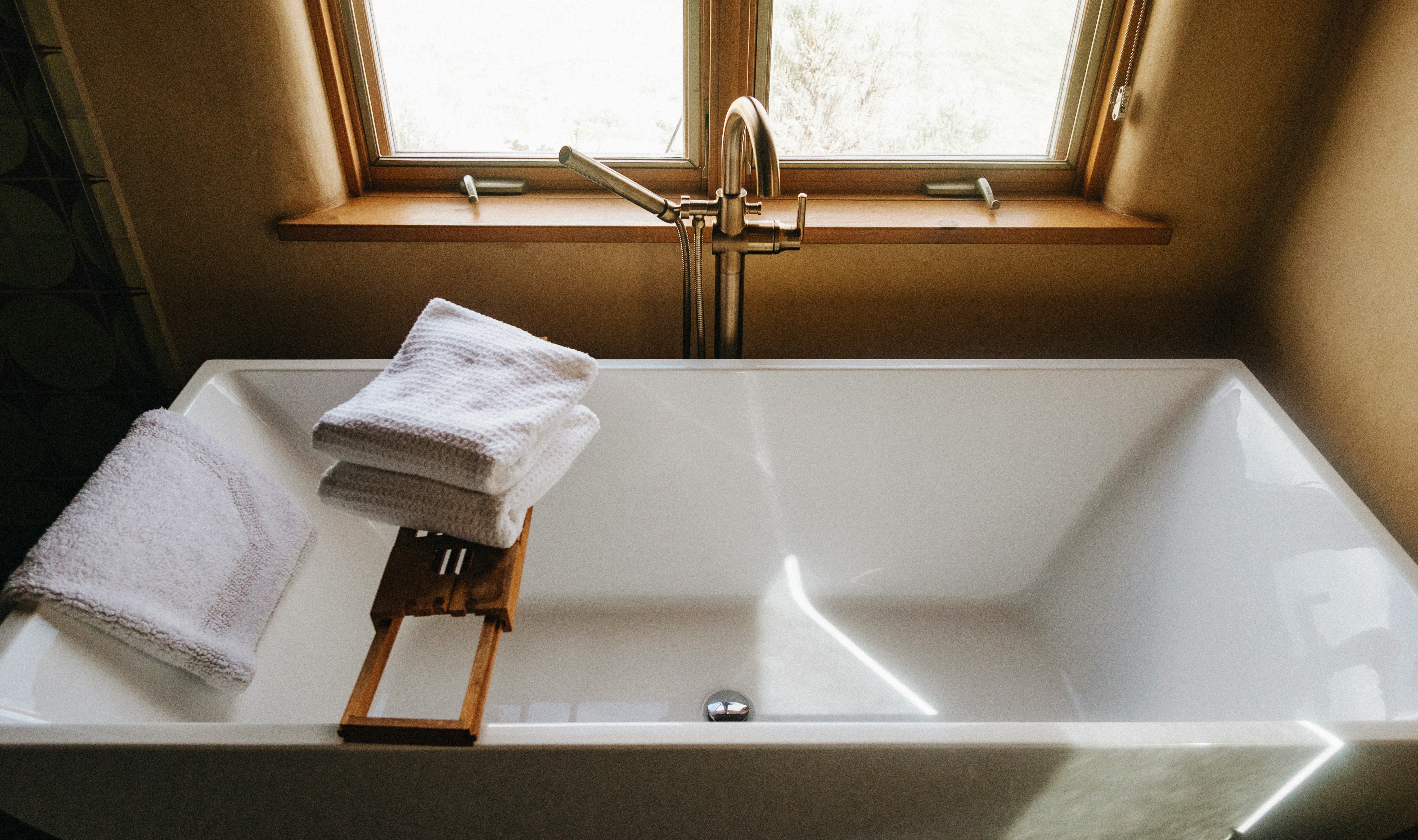 white towel on white ceramic bathtub